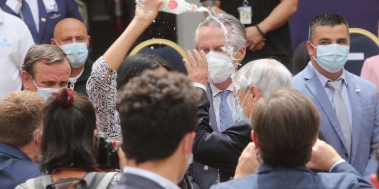 No fue un bautizo: mujer lanzó botella de agua a la cabeza del Presidente Piñera en medio de ceremonia oficial